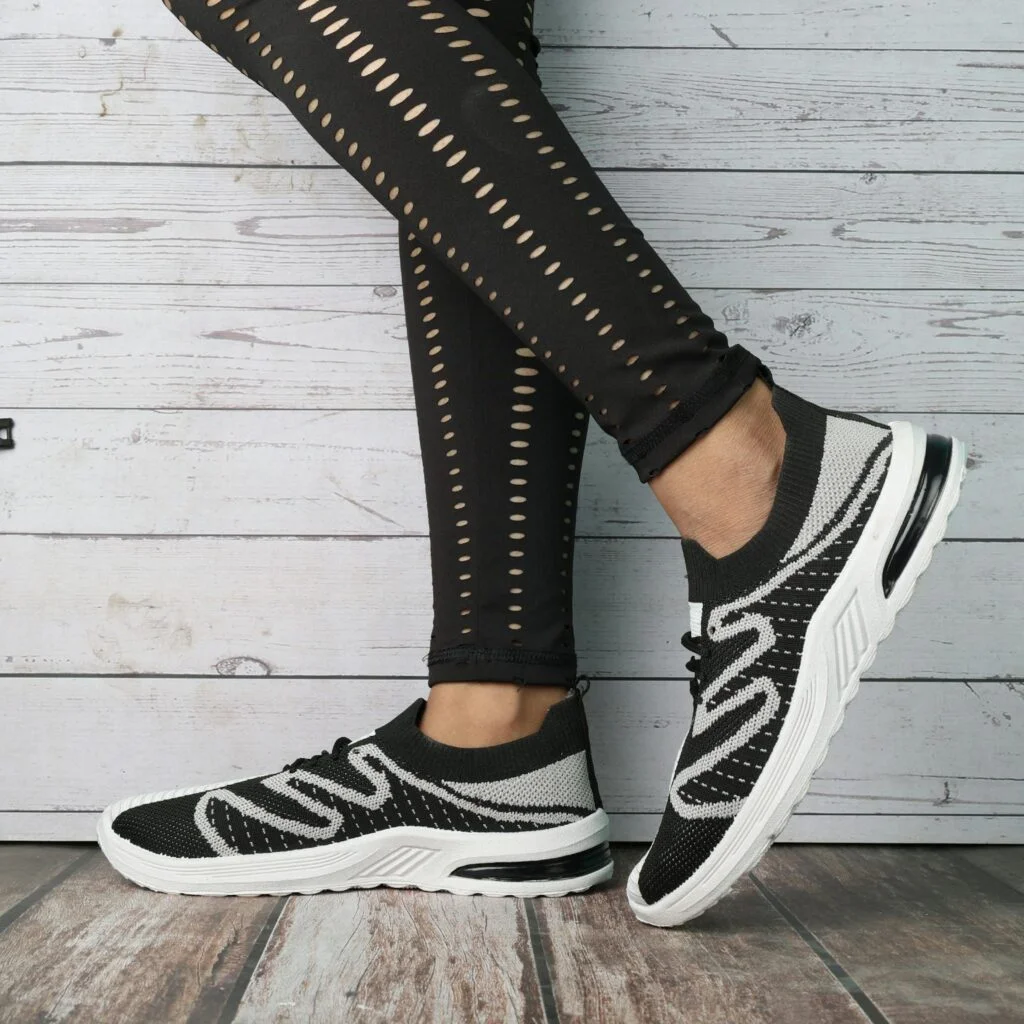 Fashionable black and white sneakers paired with trendy leggings, ideal for casual outings.